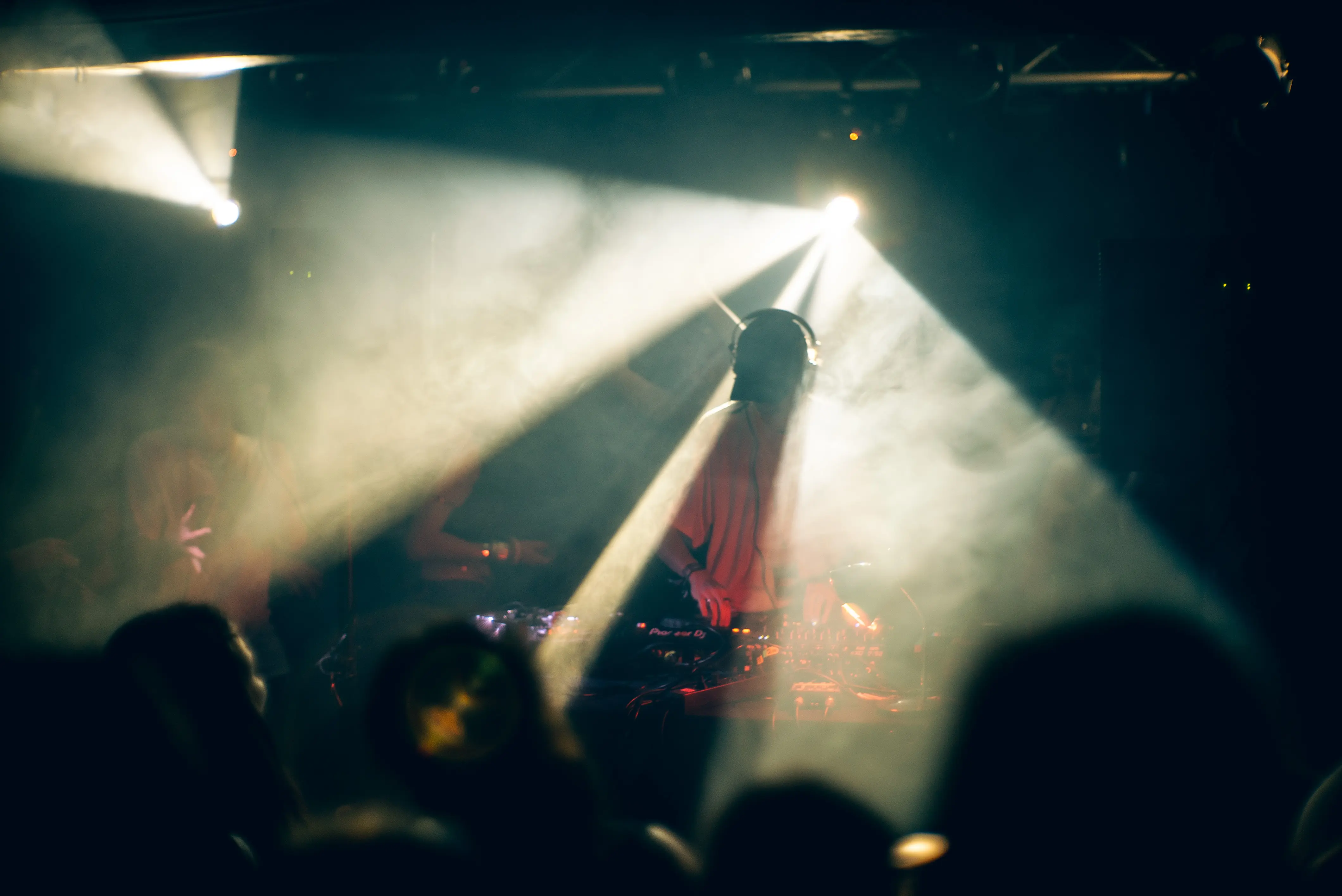 DJ-Set im Neuen Schauspiel, beleuchtet von hellen Lichtern aus verschiedenen Richtungen